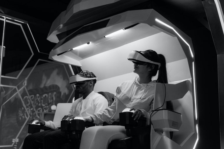 grayscale photo of two people playing virtual reality glasses